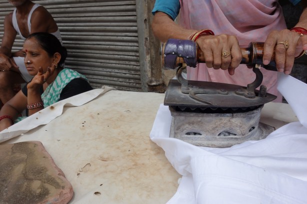 Woman ironing clothes in Chandni Chowk, Delhi, India